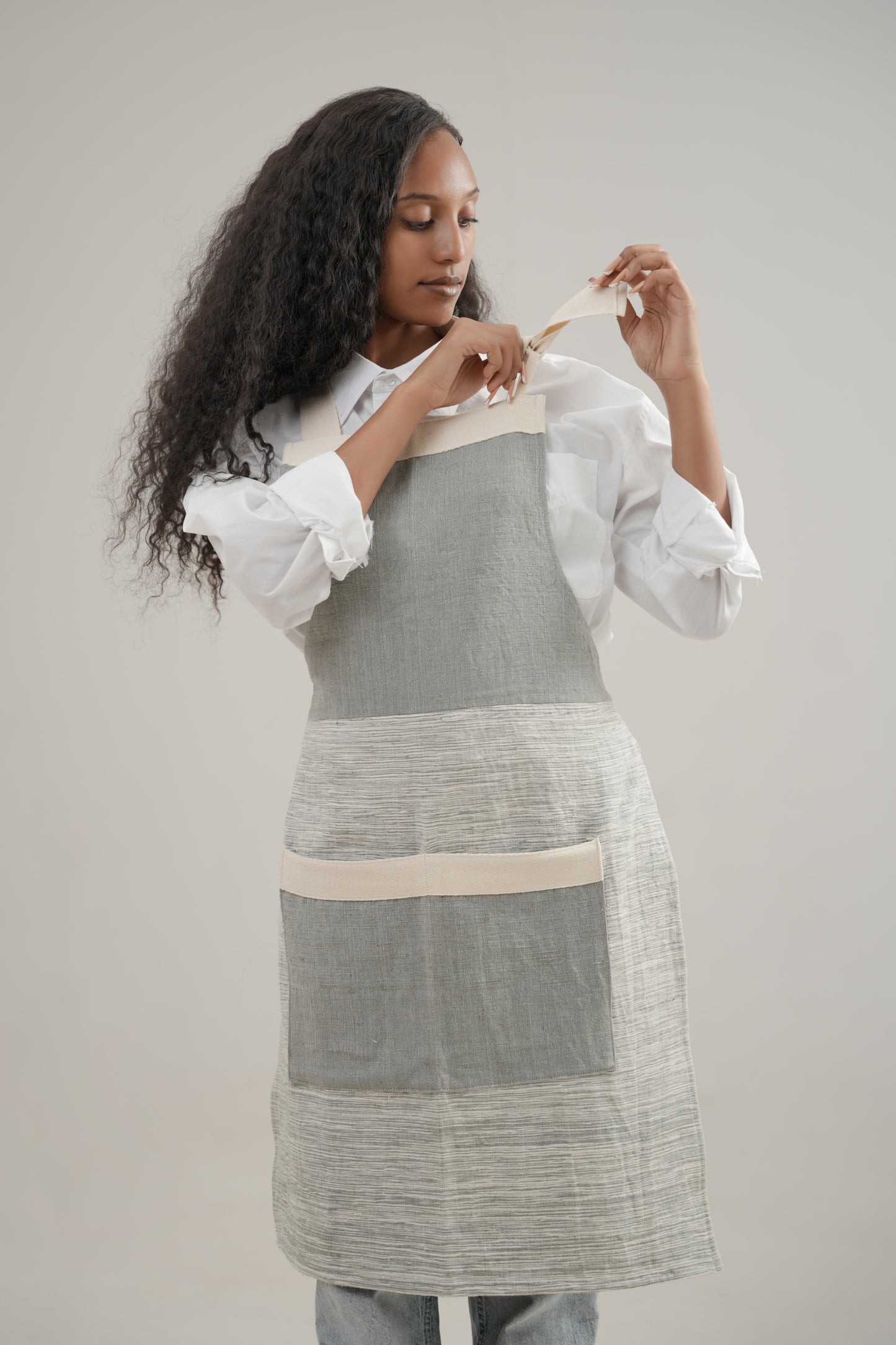 Apron in grey on ethiopian model with white background