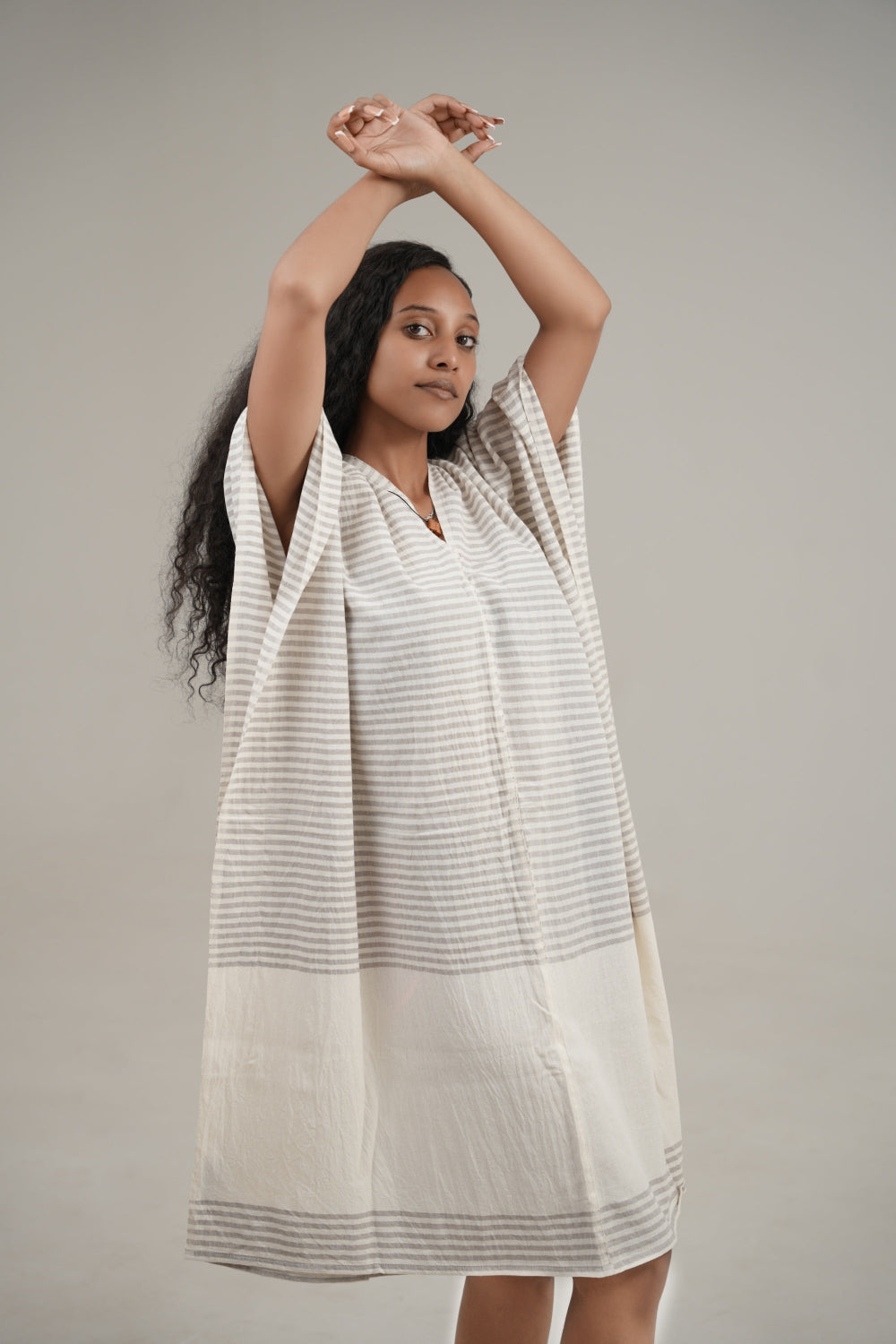 Ari kaftan in stone facing forward on model