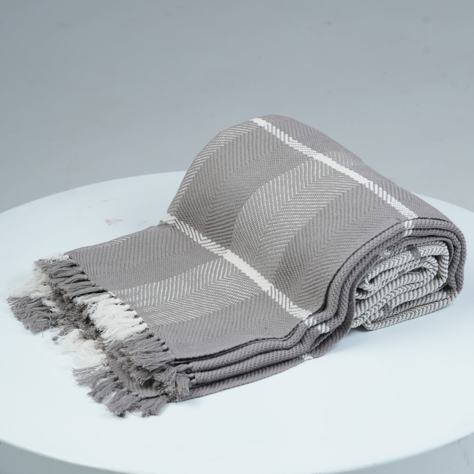 Ayele Throw Blanket Rolled on White platform