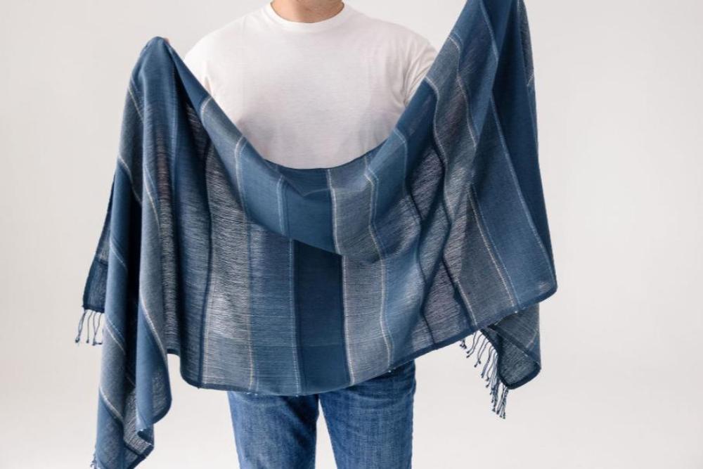 Danakil shawl in navy displayed by a male model.