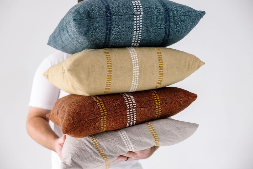 Zenach cushions being held by a model with white background
