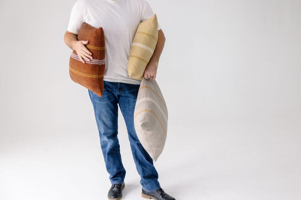 Zenach cushions held by a male model with white background
