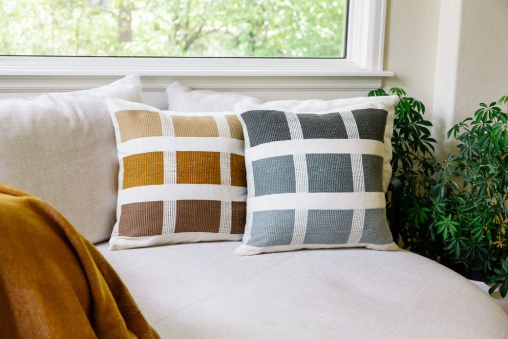 kare pillows in bronze and grey on couch with mechot throw in bronze on the side