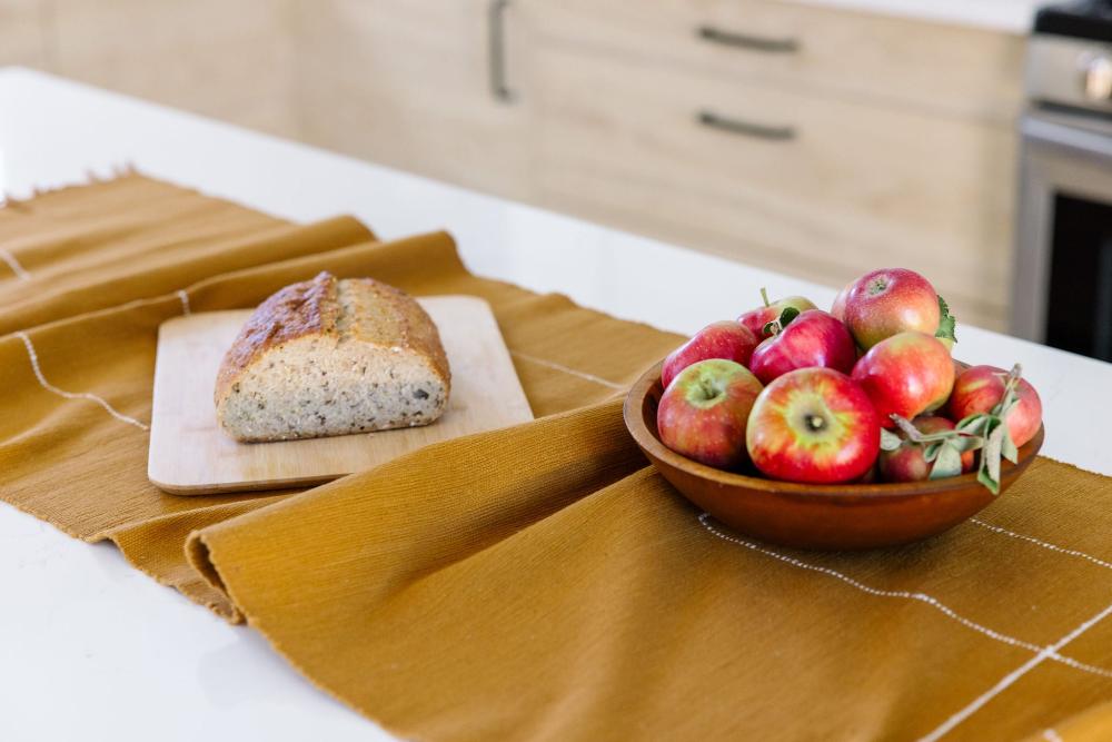 Rift Valley table runner bronze with bread and apples on a table