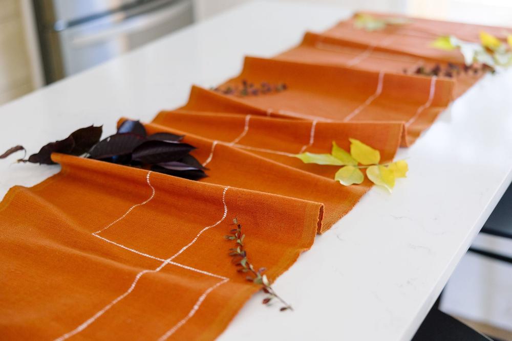 Rift Valley table runner in copper with leaves on the table