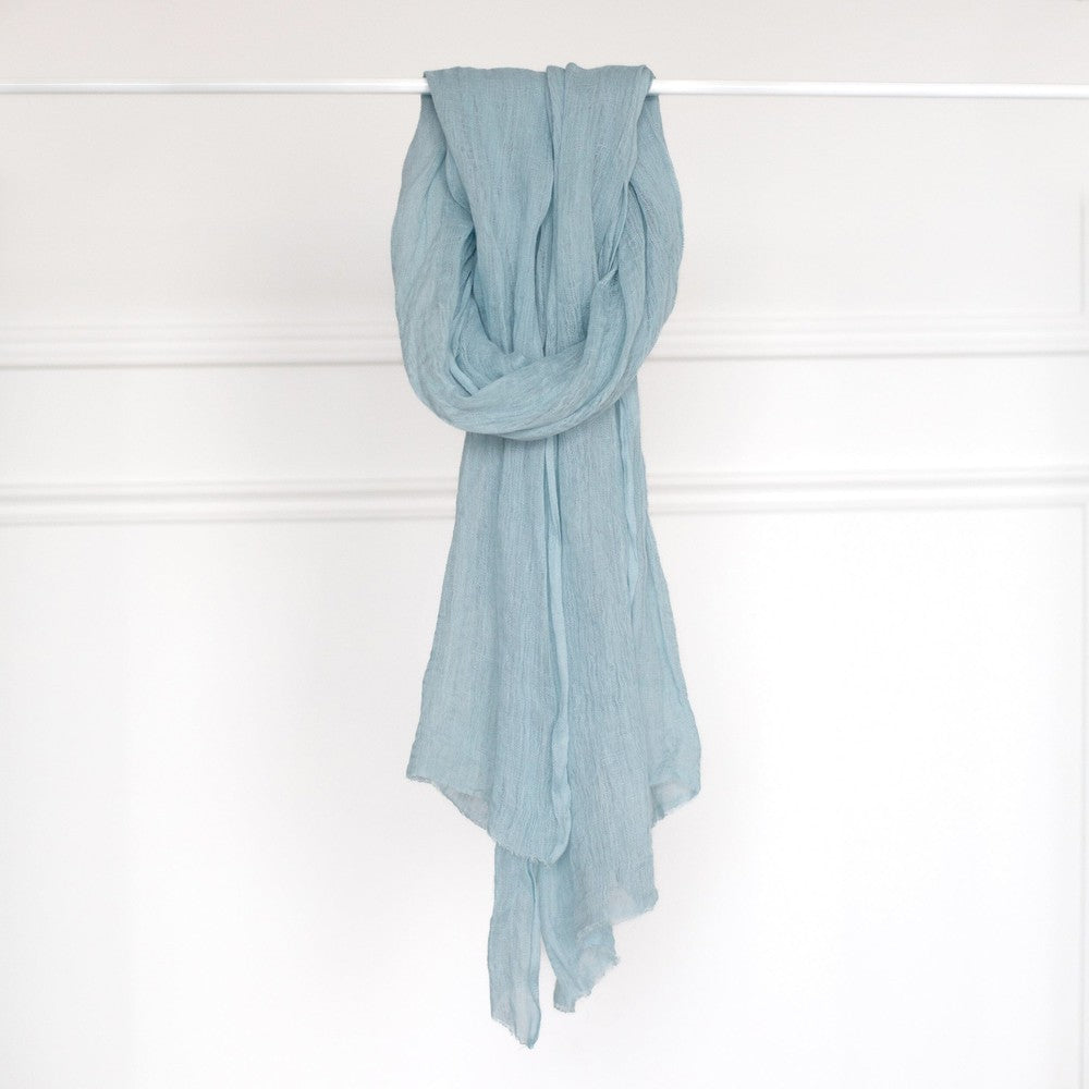 Telba linen shawl in azurro on a bar.