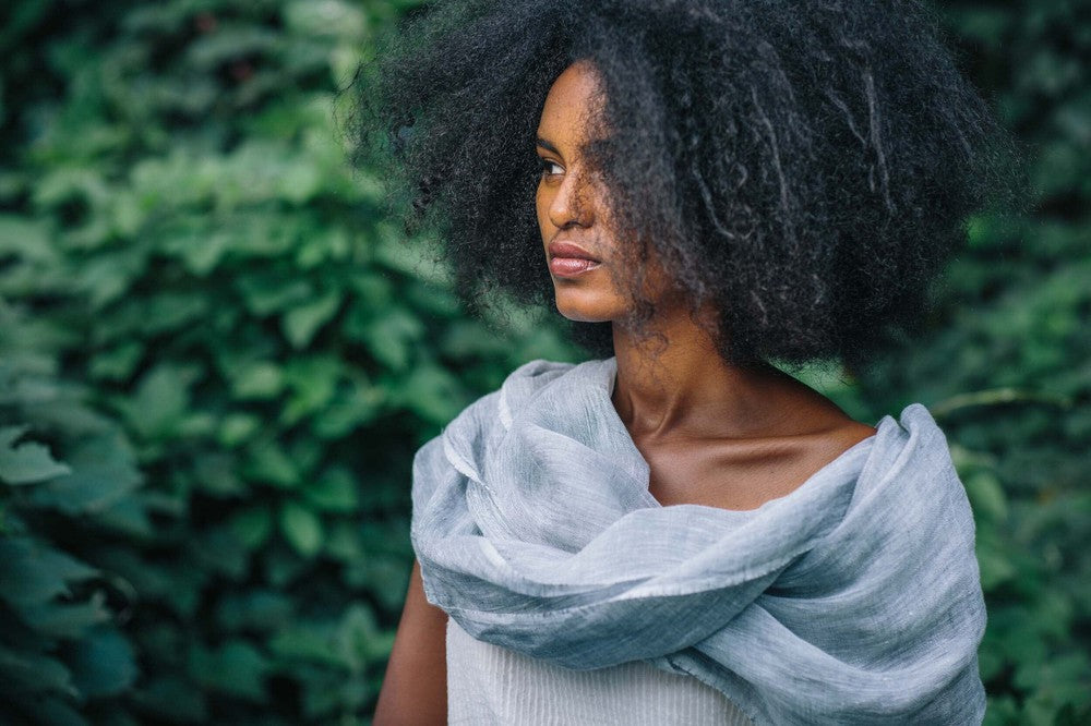 Mariam linen scarf in charchoal wrapped around female model in nature