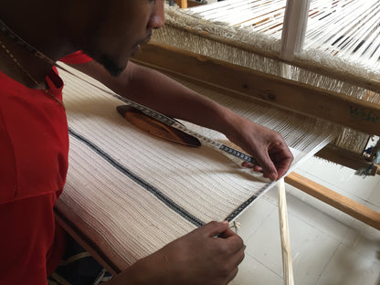 Artisan weaving wari towel on traditional loom