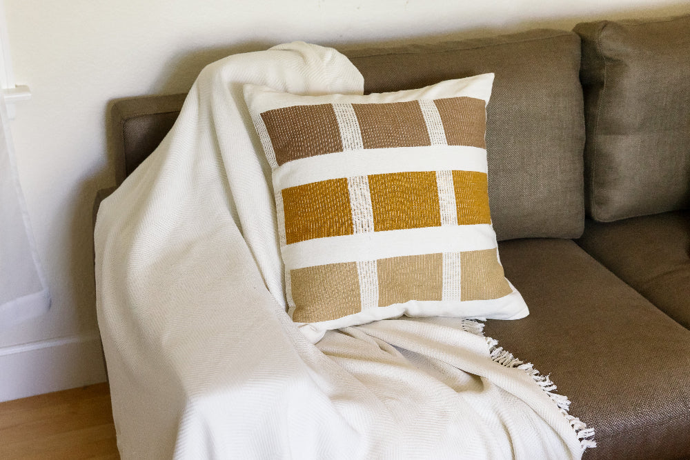 Bronze kare pillow, brown couch, ivory mechot 
