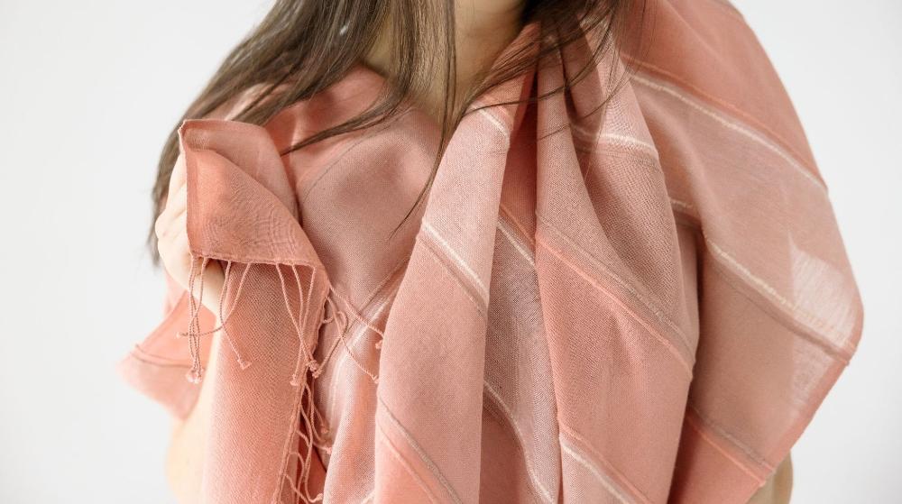 Danakil shawl in blush on a female model on white background.