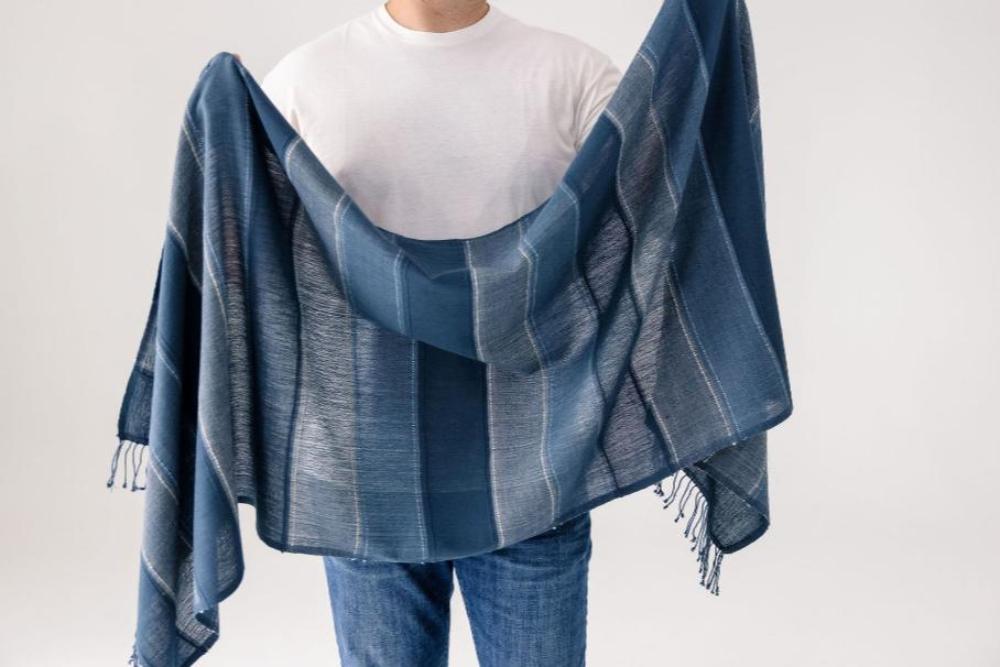 Danakil shawl in navy displayed by a male model. 