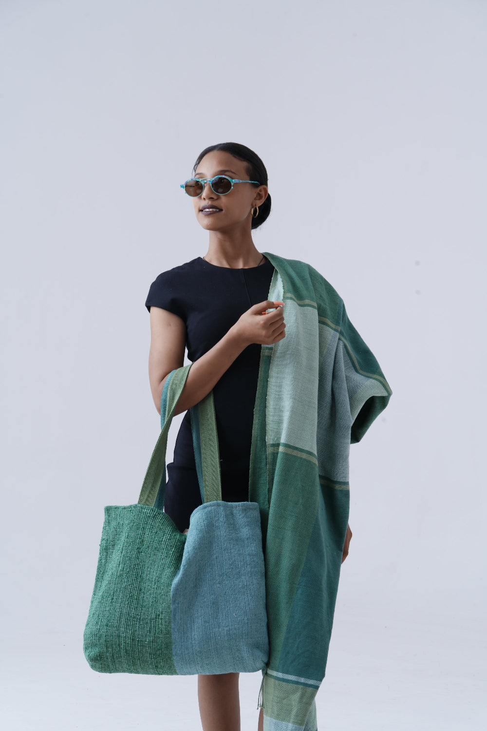 Ethiopian model holding borsa bag with mareb towel in teal hanging on shoulder