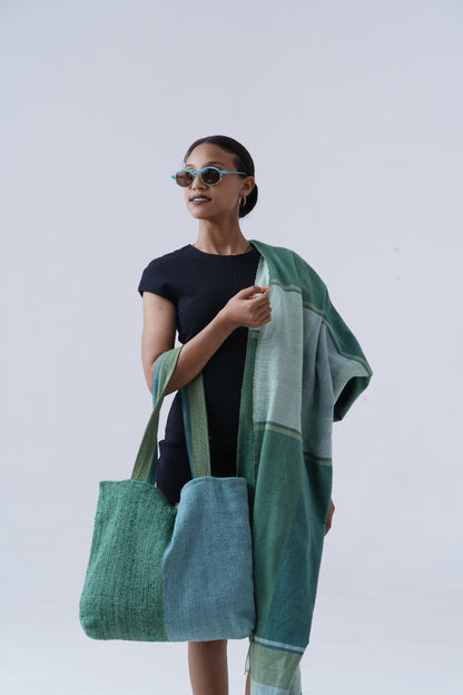 Ethiopian model holding borsa bag with mareb towel in teal hanging on shoulder