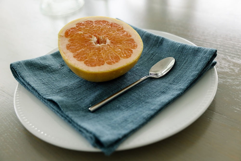 Flax Semien cocktail napkin with a grapefruit on a plate