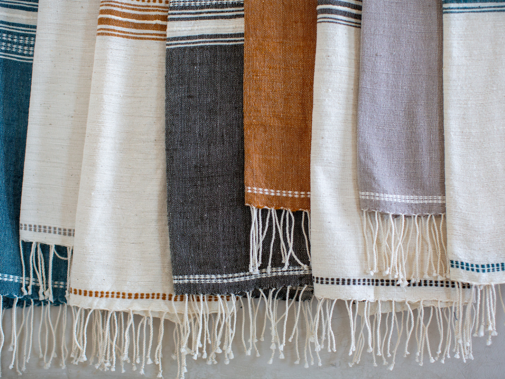 Collection of genalé towels with fringes on a neutral background