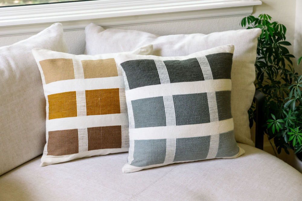 Karé throw pillow in bronze and grey on beige sofa