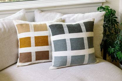 Karé throw pillow in bronze and grey on beige sofa