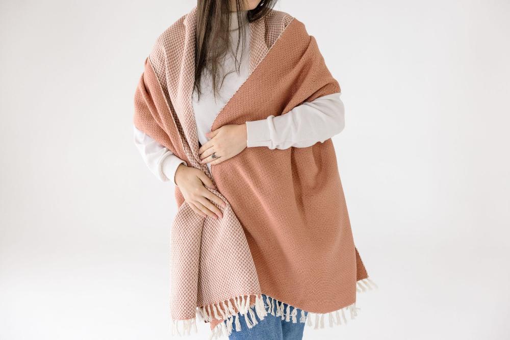 Maya shawl in blush on a model worn as a blanket