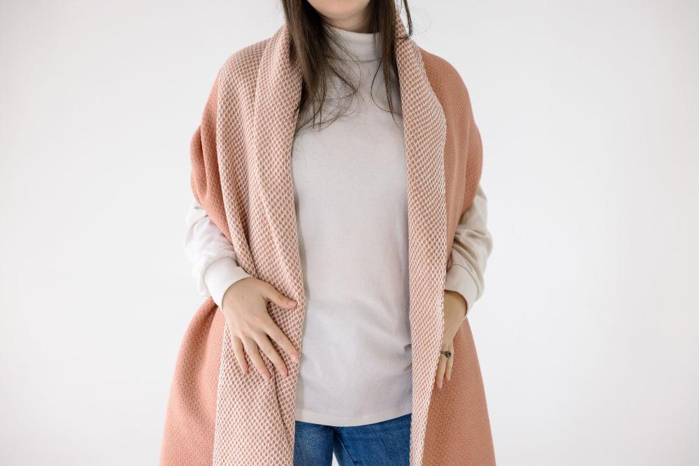 Blush and ivory Maya shawl on a female model with a white background