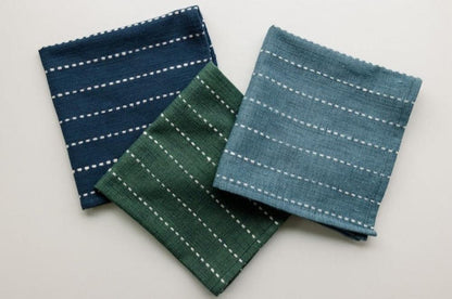 Flax, navy and cedar rift Vally napkins on a white background