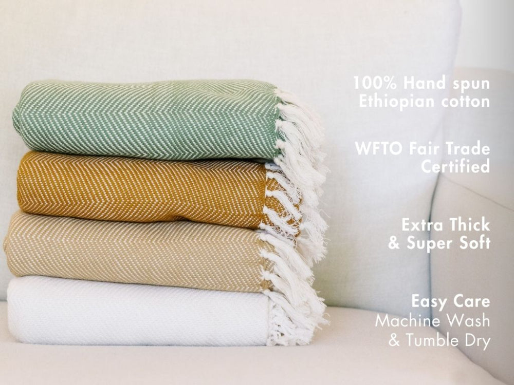 Stack of three hand-spun Ethiopian cotton blankets with text highlighting features.