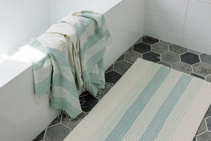 Teka bath mat in flax in bathroom with bath towel