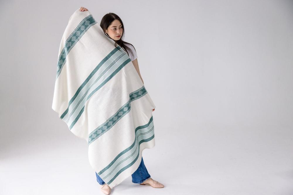 Weyra towel in azurro and teal held by model 