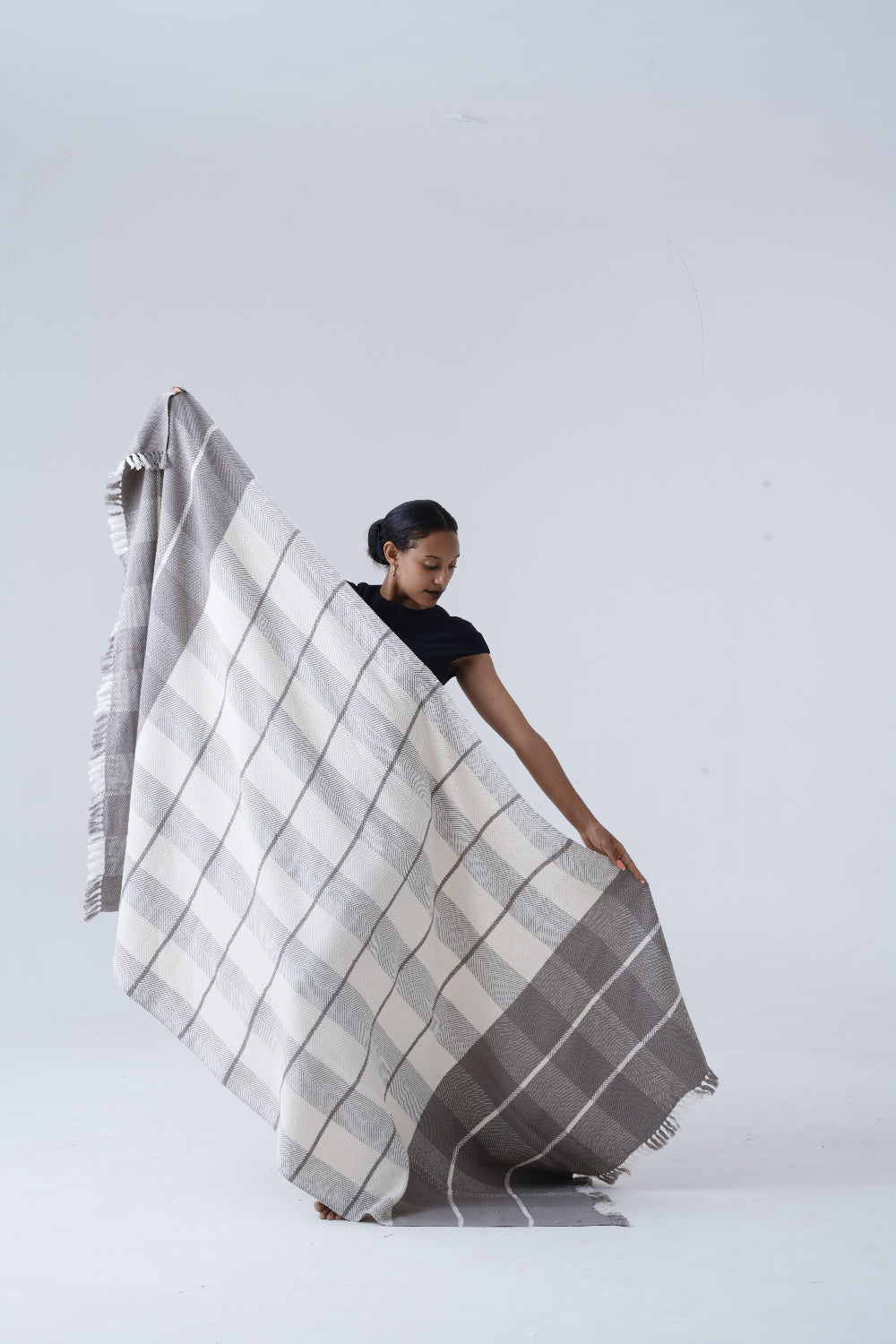 ayele blanket held by model against white background