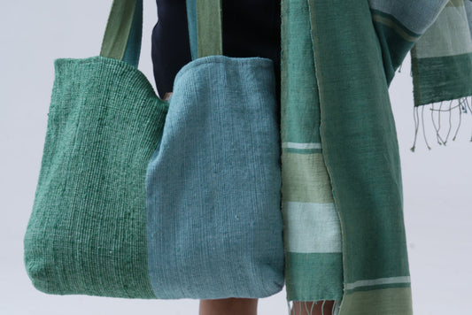 bolsa tote with mareb towel in teal carried by model on white background