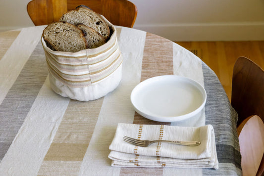 dabo basket with bread slices on tablecloth with folded chamo napkin in bronze