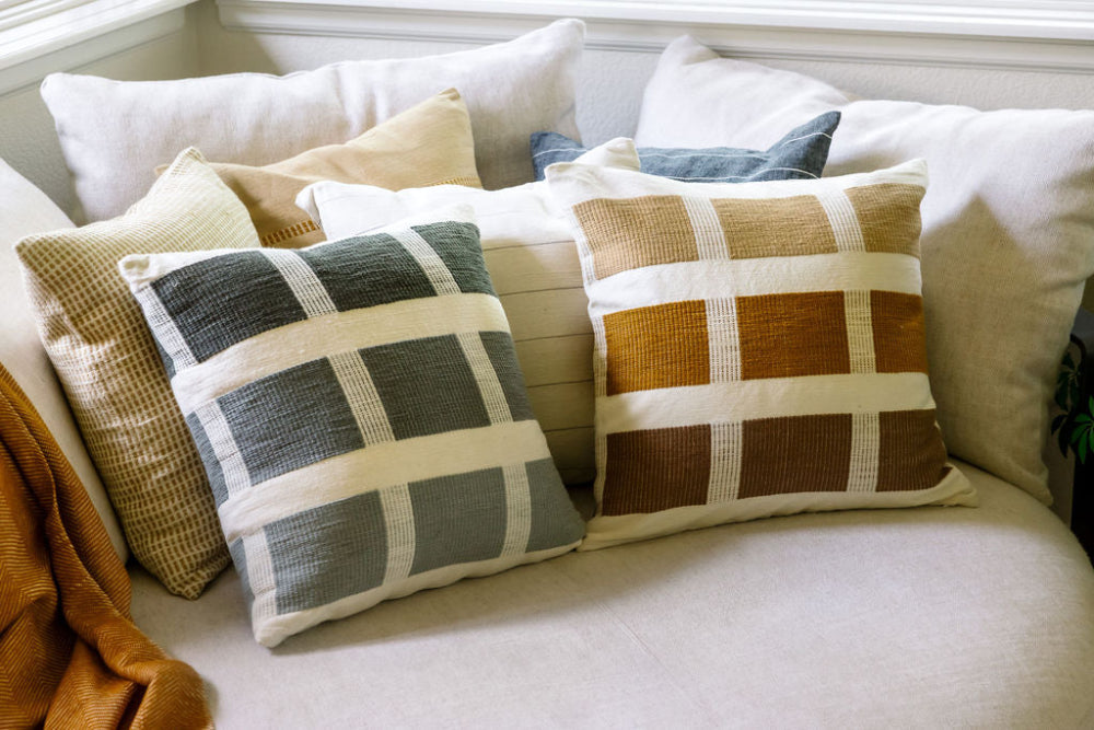 karé pillows in bronze and grey on couch 