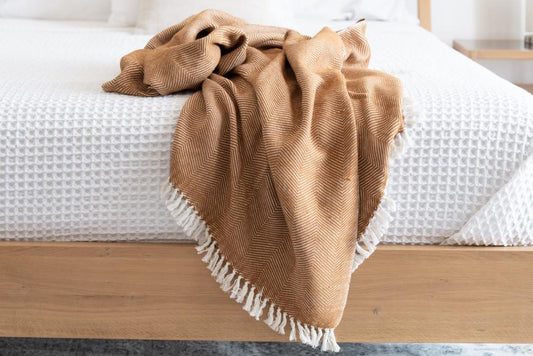 Mechot throw blanket in bronze on bed