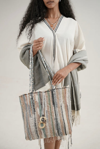 model wearing petra kaftan with abay towel and holding fasika bag 