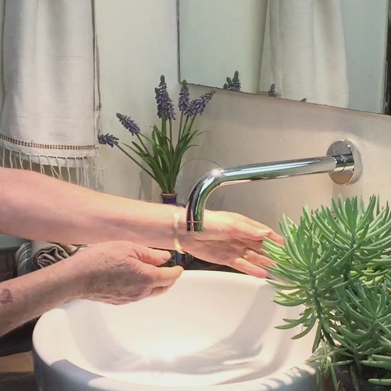 Lady using genaleé hand towel in bronze to dry her hands