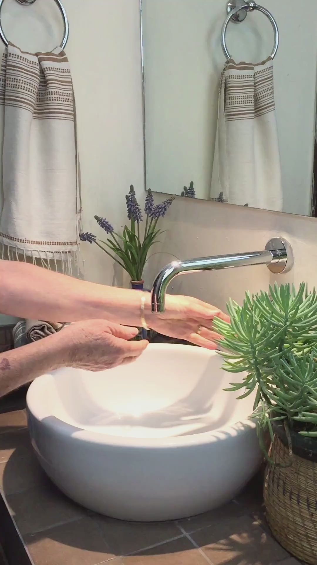Lady using genaleé hand towel in bronze to dry her hands