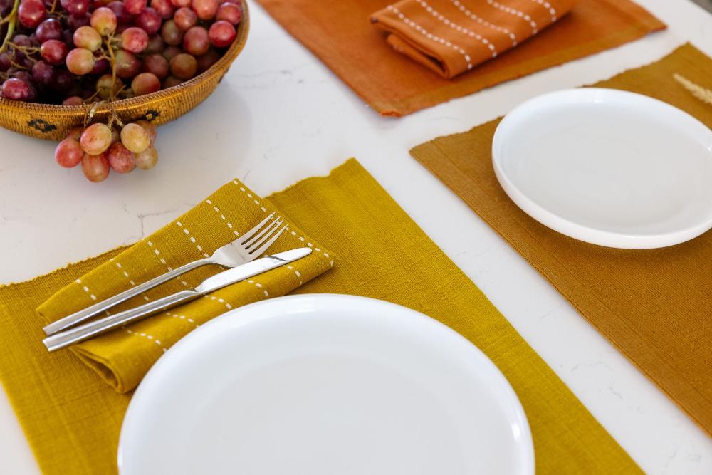 Rift Valley with Semien placemats in gold, bronze and copper with grapes on white background