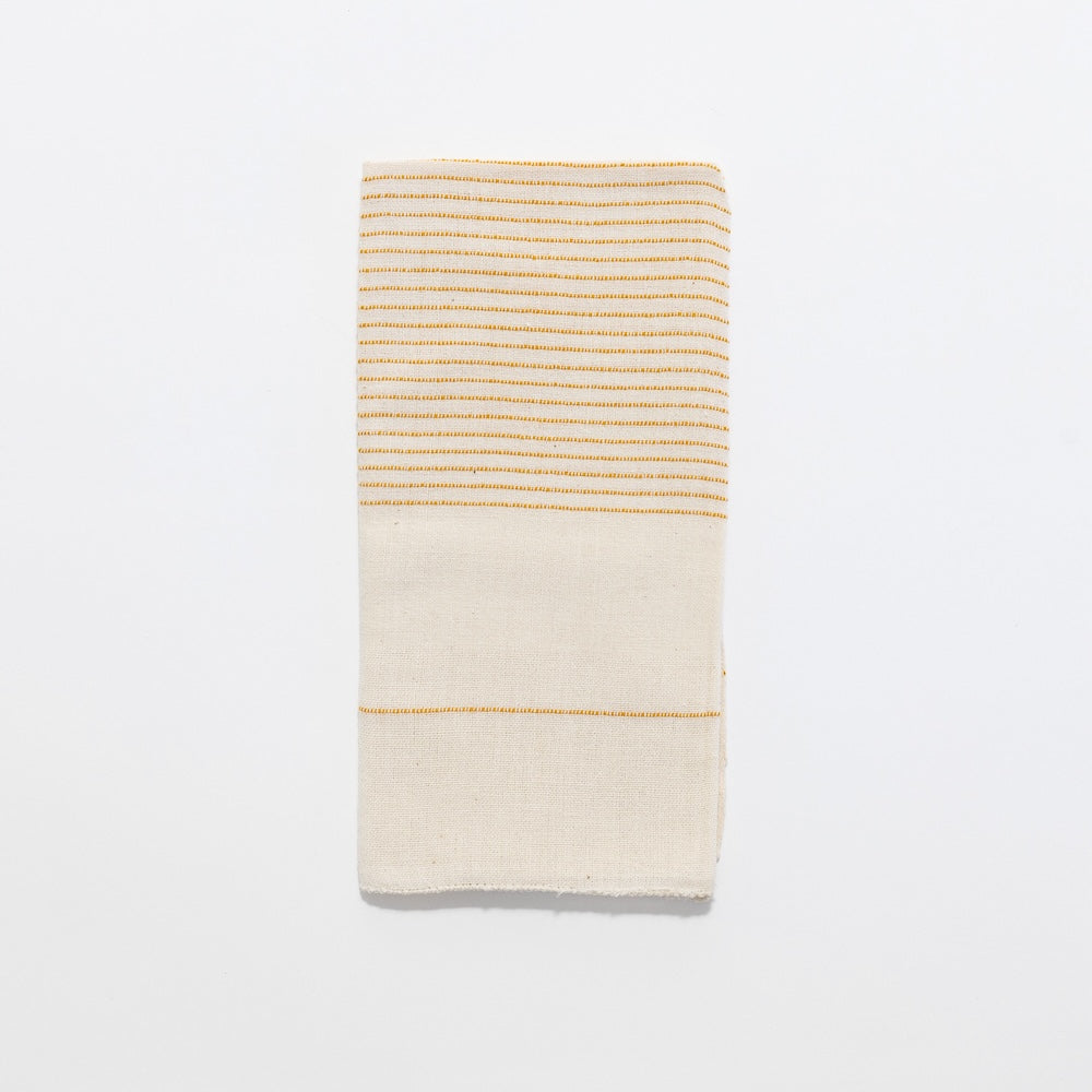 Roha napkin in gold flat lay on a white background