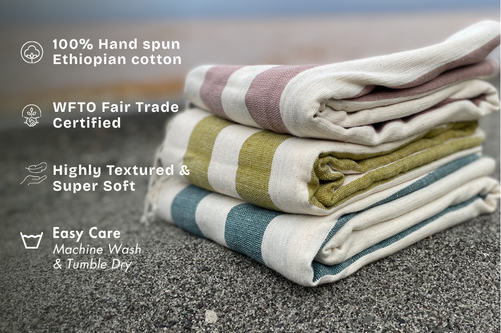 stack of folded omo towels at the beach