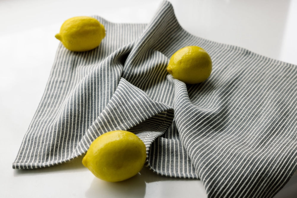 turkana tea towel in grey with lemons on white background