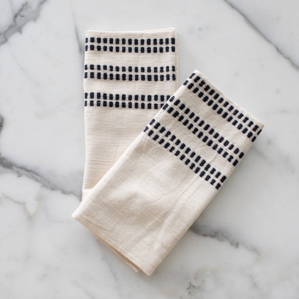 Two Sodo napkins in black on a marble background