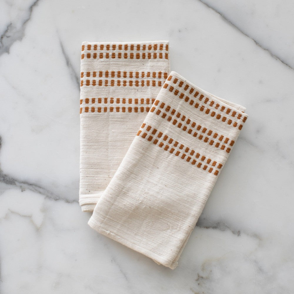 Two Sodo napkins in bronze on a marble background