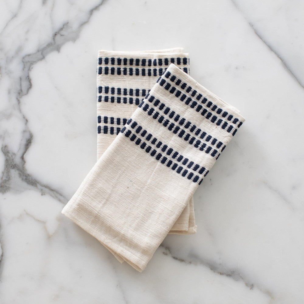 Two Sodo napkins in navy on a marble background